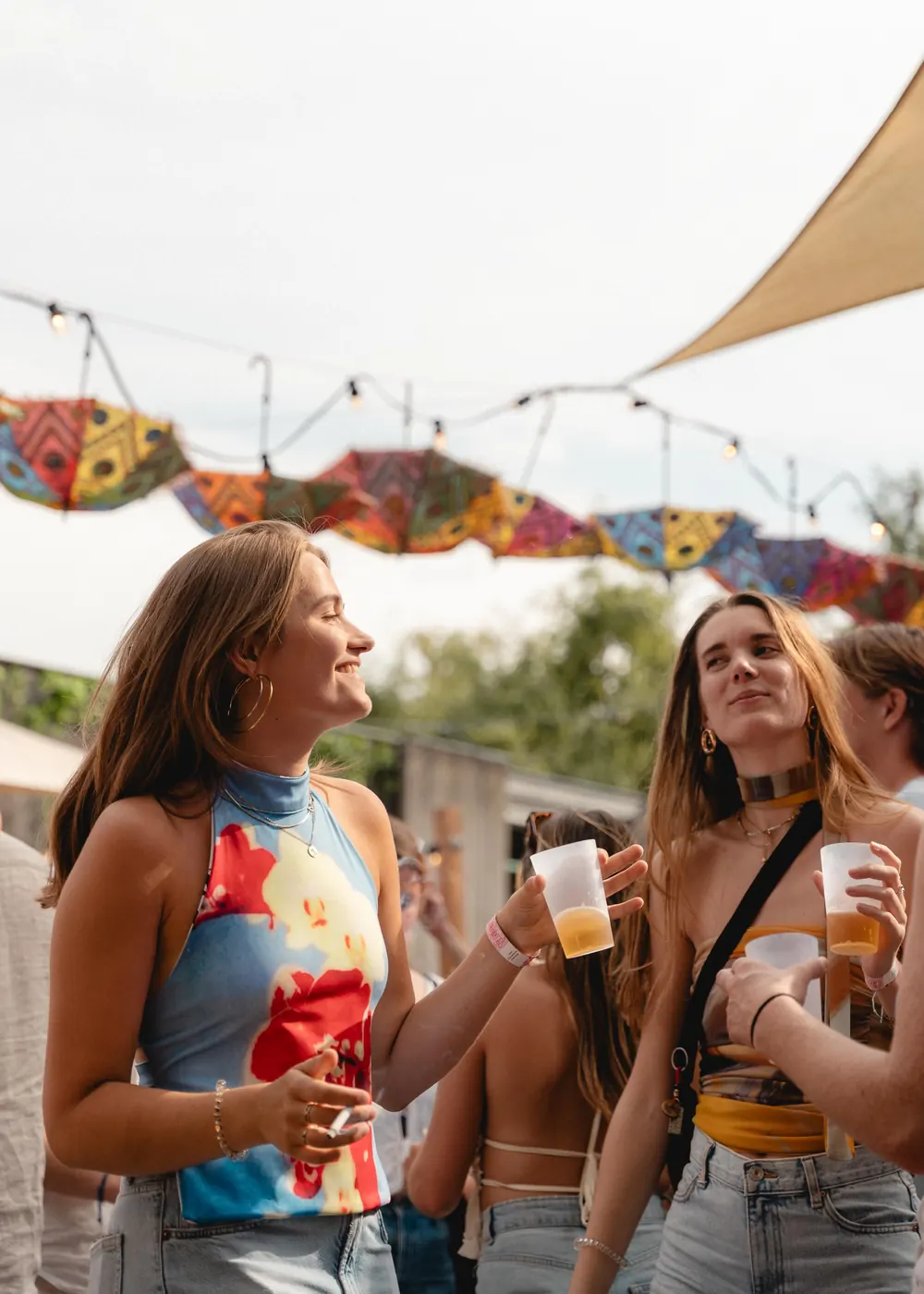 Bezoekers met een drankje onder de parasols op Miami Nice 2025